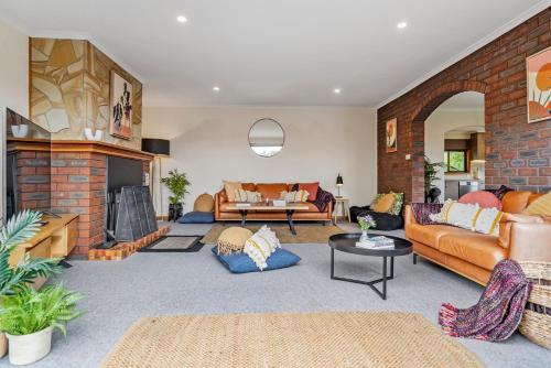 uma sala de estar cheia de mobiliário e uma parede de tijolos em Lumeah Retreat Bruny Island em Adventure Bay