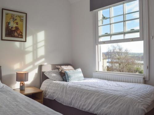 a bedroom with two beds and a window at Ty Glyndwr in Goodwick