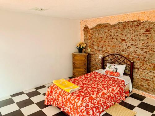 a bedroom with a bed and a brick wall at Casa Rústica in Atlixco