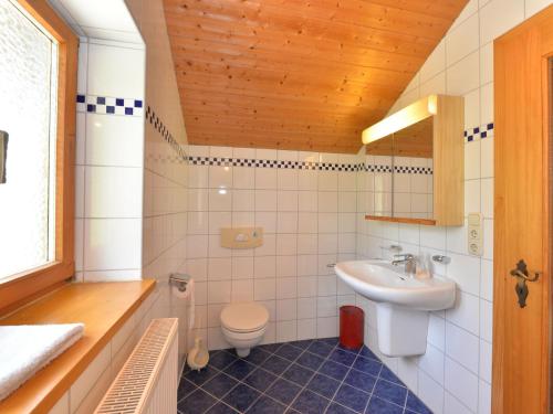 ein Bad mit einem Waschbecken und einem WC in der Unterkunft Spacious Holiday Home in Zenting with Private Garden in Zenting