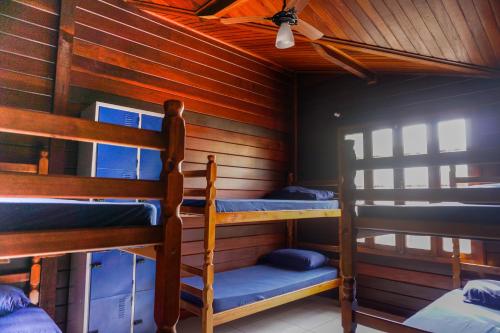 a room with two bunk beds in a cabin at Hostel Carcará in Caraguatatuba