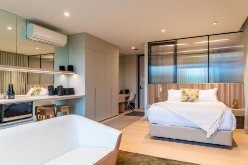 a bedroom with a large white bed and a kitchen at Beresford Estate in McLaren Flat
