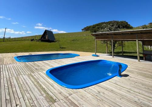 two blue trays on a wooden deck with a tent at Hotel Guerra - Pousada Montebelo in Jaguaruna