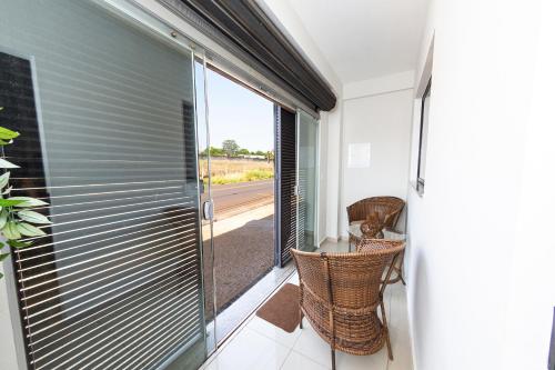 a balcony with a sliding glass door with a view of a road at Jahu Center Plaza Flats in Jaú