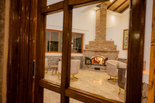 a living room with a fireplace and a table and chairs at Llamita Hotel-Huancayo in Huancayo