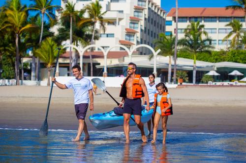 a group of people standing in the water on the beach at Occidental Nuevo Vallarta - All Inclusive in Nuevo Vallarta 