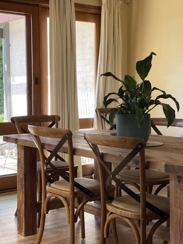 Una mesa de madera con sillas y una planta en maceta encima. en Residence on Cemar - Home Away from Home, en Orange