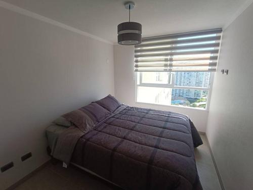 a bedroom with a bed and a window at Arriendo Depto. Diario Coquimbo in Coquimbo