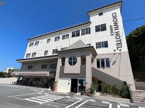 a white building with a sign on it at Crown Hotel Okinawa Annex in Okinawa City