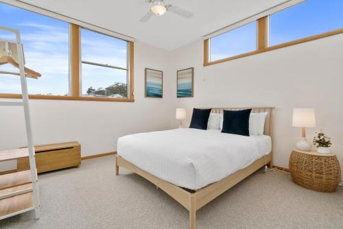 a bedroom with a bed and some windows at Blue Cottage Bruny Island in Alonnah