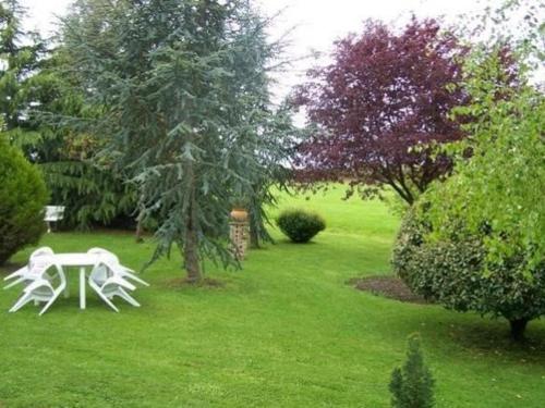 a garden with a table and chairs in the grass at Charmante maison de campagne avec vaste parc arboré, cheminée et multiples activités à proximité - FR-1-410-153 in Moulins-le-Carbonnel