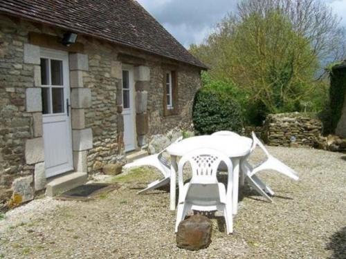 a white table and chairs in front of a building at Charmante maison de campagne avec vaste parc arboré, cheminée et multiples activités à proximité - FR-1-410-153 in Moulins-le-Carbonnel