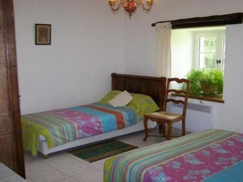 une chambre avec deux lits et une chaise et une fenêtre dans l'établissement Charmante maison de campagne avec vaste parc arboré, cheminée et multiples activités à proximité - FR-1-410-153, à Moulins-le-Carbonnel