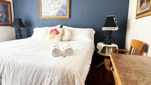 a bedroom with a bed with towels and a dog on it at Hotel La More at The Bisbee Inn in Bisbee