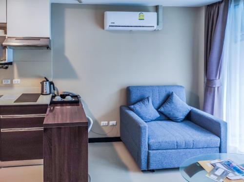 a blue chair sitting in a room with a kitchen at MBC Mai Khao Beach Condotel LUXURY APARTMENTs in Phuket
