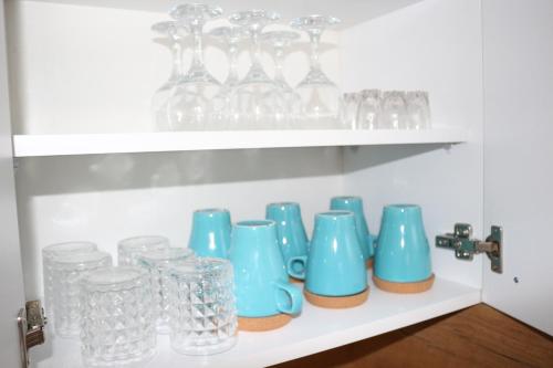 a shelf filled with glass vases and glasses at Apartman Nina, Kopaonik, Brzeće, Kod Gondole in Brzeće