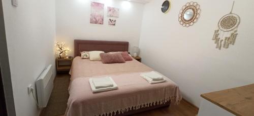 a small bedroom with a bed with a pink blanket at Apartman Nina, Kopaonik, Brzeće, Kod Gondole in Brzeće