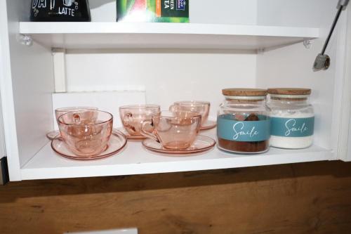 a shelf with cups and jars on it at Apartman Nina, Kopaonik, Brzeće, Kod Gondole in Brzeće