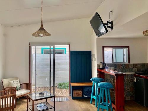 a living room with a kitchen with blue stools at Posada Agua Marina in La Paloma