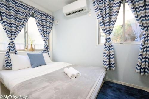 een slaapkamer met een bed met blauwe en witte gordijnen bij Skytree Easy Access Tokyo Apartment - Bell Flat Inn #1 in Tokyo