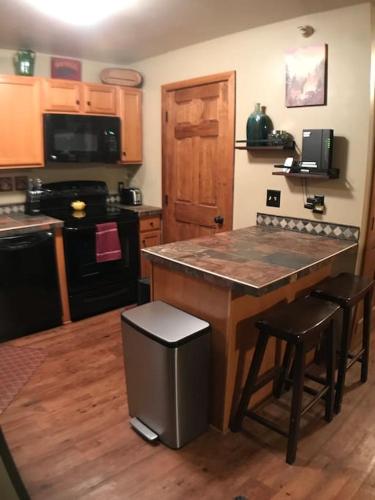a kitchen with a large island with stools in it at Rustic 2 BR Mountain View-walk to resort in Big Sky