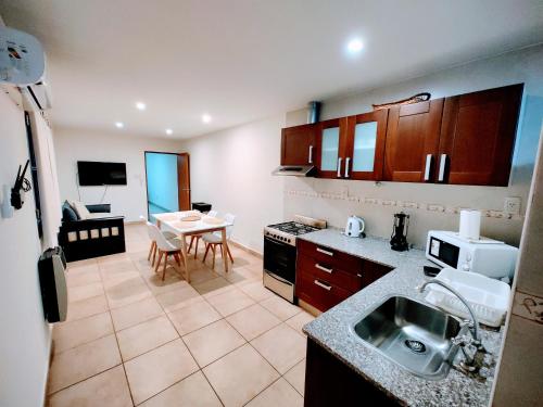 Infinity lounge apartment, lujoso, céntrico y amplio في سان رافاييل: مطبخ مع حوض وطاولة في الغرفة