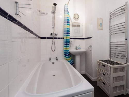 a white bathroom with a tub and a sink at Lower Street 10 Flat 3 in Dartmouth