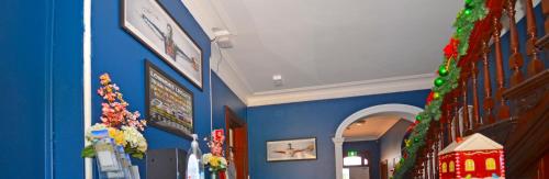 a hallway with blue walls and christmas decorations at The Hallows Accommodation in Bathurst
