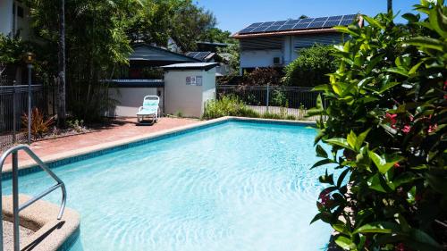 a swimming pool with a chair in front of a house at Entertainer on Martyn in Cairns