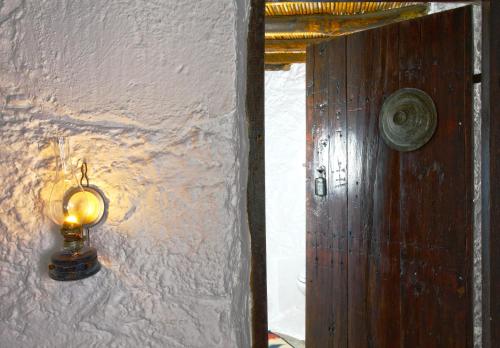 a light on a wall next to a door at Aspros Potamos in Makry Gialos