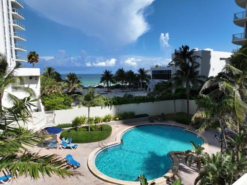 a view of the pool from the balcony of a resort at Hollywood Beachfront Condo, Steps to Ocean, Pool & Game Room in Hollywood