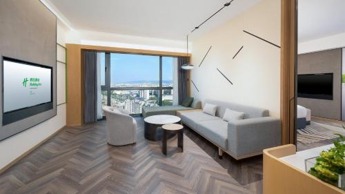 a living room with a couch and a tv at Holiday Inn Yongkang in Jinhua
