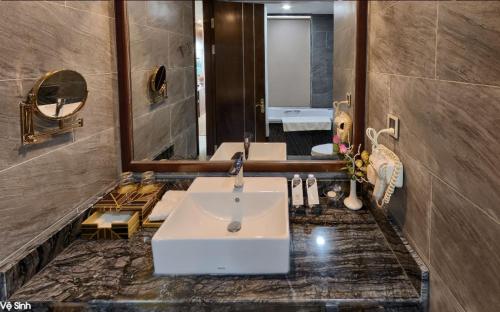 a bathroom with two sinks and a large mirror at Le Indochina Hotel in Bắc Ninh