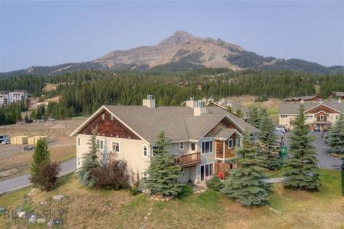 an aerial view of a house with a mountain in the background at Cozy 2 BR Mountain View - walk to resort in Big Sky