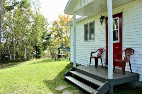two chairs sitting on the porch of a house at Chalet Au Bord du St-Maurice in La Tuque