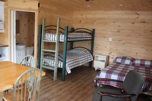 a room with two bunk beds and a table at Chalet Au Bord du St-Maurice in La Tuque