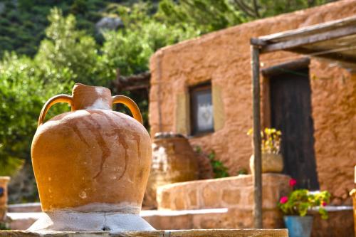 a statue of a vase in front of a building at Aspros Potamos in Makry Gialos