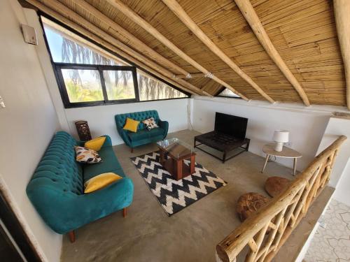 a living room with a green couch and a television at Oasis de Vichayito in Vichayito