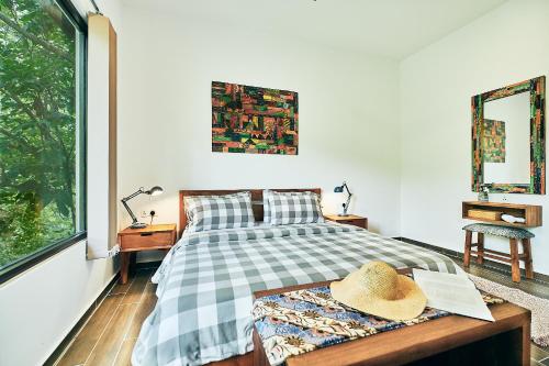 a bedroom with a bed with a hat on it at Ranis Lodge in Kampung Padang Masirat