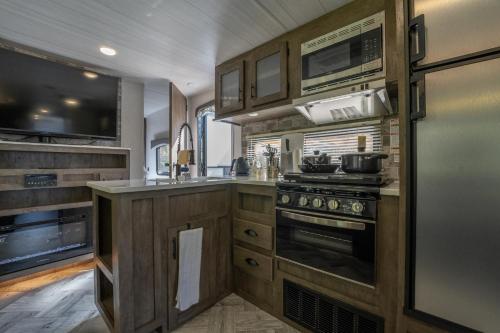 a kitchen with wooden cabinets and a stove top oven at 淡島シーサイドコテージ in Anan