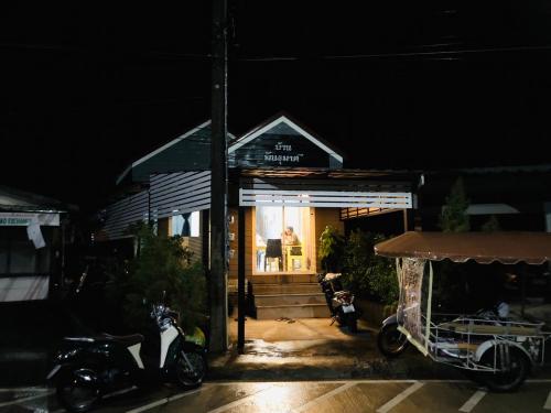 a store with motorcycles parked outside of it at night at Hunny Home in Ko Yao Noi