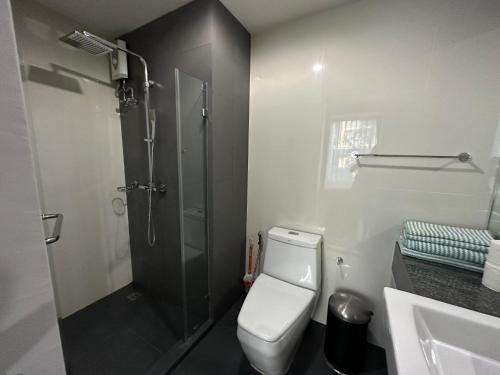 La salle de bains est pourvue d'une douche, de toilettes et d'un lavabo. dans l'établissement Phuket apartment surin beach, à Thalang
