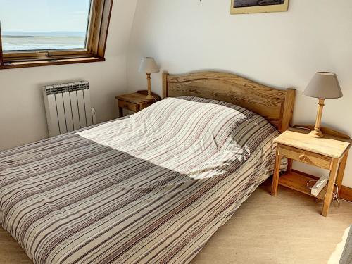 a bedroom with a large bed and a window at Appartement Duplex en Front de Mer avec Terrasse – Accès Direct Plage – 2 Chambres + Cabine - FR-1-361-456 in Saint-Pair-sur-Mer