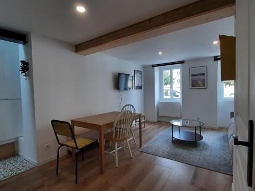 une salle à manger et un salon avec une table et des chaises dans l'établissement Appartement cosy à Biarritz, proche des Halles et plages, idéal pour 2 avec wifi inclus - FR-1-239-853, à Biarritz