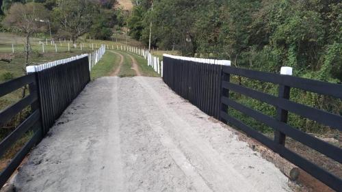 een onverharde weg met een hek aan de zijkant bij Sítio Vale do Sol in Pinhalzinho