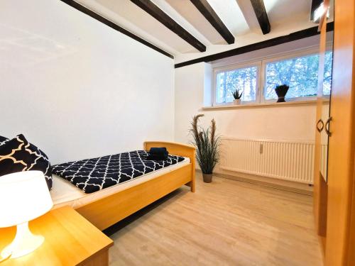 1 dormitorio con cama y ventana en Galerie-Ferienwohnung "Im Schindlershof" - zentral und ruhig, en Eibenstock