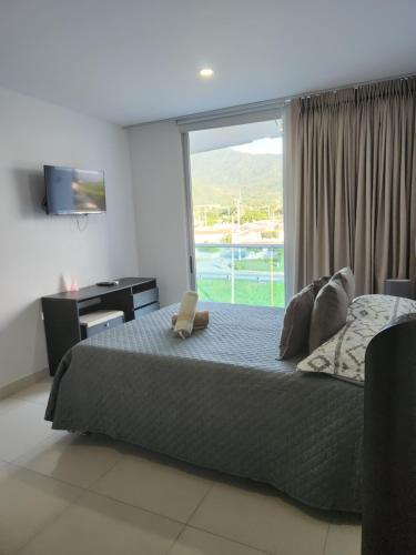 a bedroom with a bed with a window and a desk at Hermoso apartamento. Cerca del mar. in Santa Marta