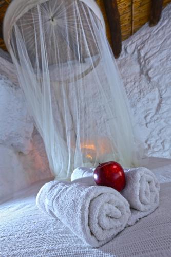 a towel and a red apple on a bed at Aspros Potamos in Makry Gialos