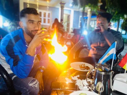 un uomo seduto a un tavolo con un fuoco di Hotel New Darshan a Pokhara