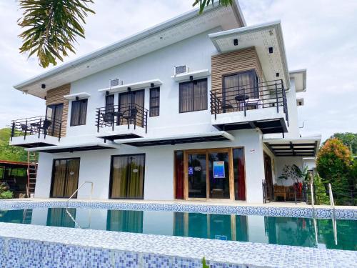 a house with a swimming pool in front of it at Casa De Española Hotel and Resort in Aritao